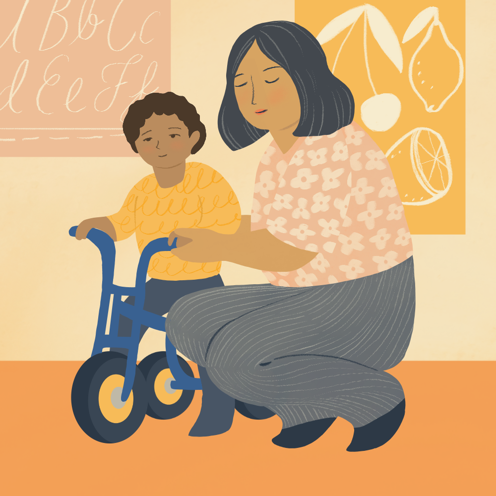 An illustration of a child care provider kneeling next to a young boy riding a blue tricycle. The child care provider has short, dark hair, wears a pink shirt and grey pants. The child has curly black hair, wears a yellow shirt and dark blue pants. In the backgound are posters of the alphabet and different types of fruit.